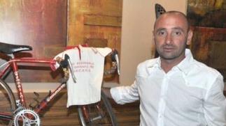 Paolo Bettini con la bici e alcuni piccoli atleti