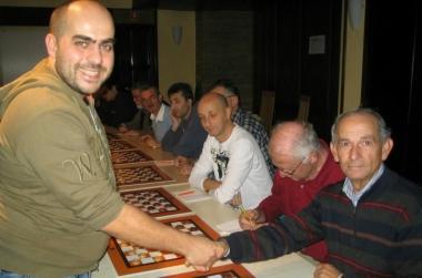 A sinistra Michele durante una partita in simultanea, al centro la premiazione al termine di un test match e a destra un momento in cui il campione si concentra 