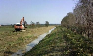 Un mezzo del consorzio Auser al lavoro lungo un canale 