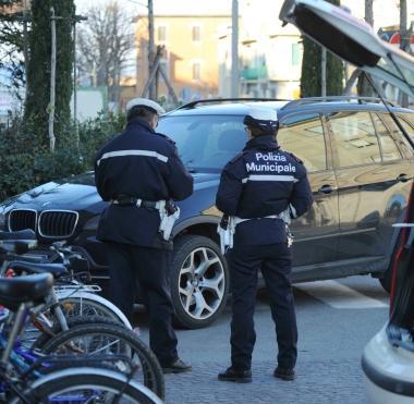 Educazione stradale in una scuola. Sopra, vigili urbani impegnati ad elevare una multa per sosta vietata 