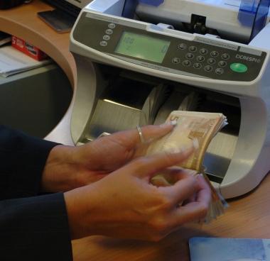 Si contano i soldi ad uno sportello bancario 