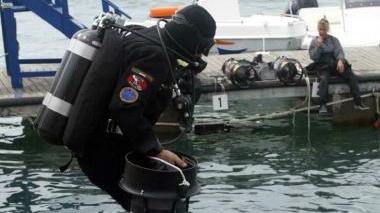 Un sub e un geotubo arenato in spiaggia