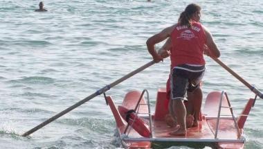 Bagnini impegnati ai remi sul patino di salvataggio 