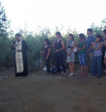 Il prete e un gruppo di fedeli durante la cerimonia in via Pian di Rota 