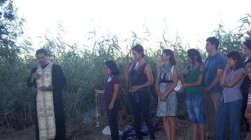 Il prete e un gruppo di fedeli durante la cerimonia in via Pian di Rota