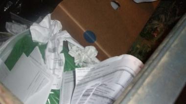 I fogli di carta trovati dentro al cassonetto riservato ai rifiuti organici      