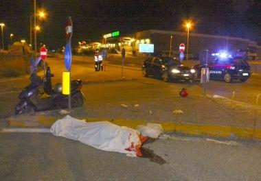 Il corpo della vittima coperto dal lenzuolo sul cordolo rialzato dellincrocio 