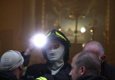 Un vigile del fuoco appena uscito dai locali invasi dal fumo: serviva la torcia per vedere bene 