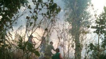 Volontari e pompieri durante le operazioni di spegnimento dell’incendio sulla collina alle spalle del palazzo della Telecom