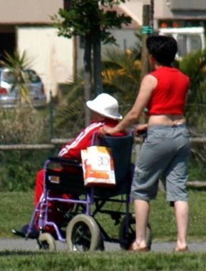 Una badante assiste unanziana costretta su una sedia a rotelle  