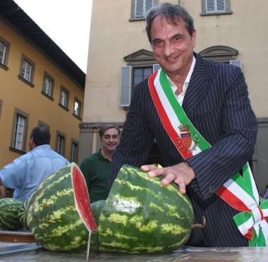 A destra l’avvio della cocomerata Sotto il sindaco Roberto Cenni taglia la prima fetta di cocomero