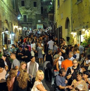 Un angolo di Campiglia gremito di gente e tre artisti di strada 
