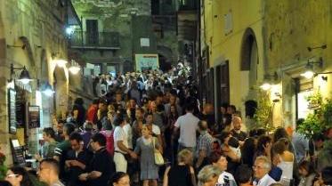 Un angolo di Campiglia gremito di gente e tre artisti di strada