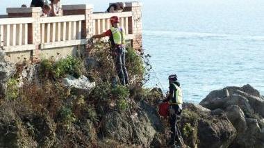 Scalatori lombardi appesi agli scogli per pulire la ripa di piazza Bovio