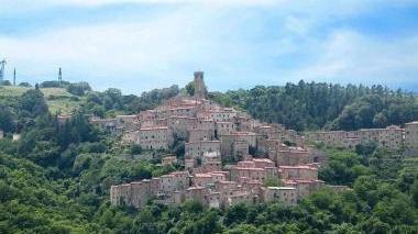 Una veduta di Castelnuovo e, in basso da sinistra, i sindaci dei Comuni dell’Alta Valdicecina Alberto Ferrini, Sandro Cerri, Loris Martignoni e Marco Buselli