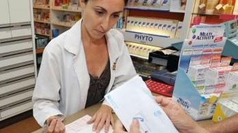 Una cliente nella farmacia Viti mostra i documenti Inps