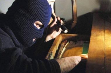 Un ladro entrato di notte in una casa fruga nei cassetti  