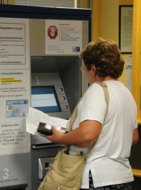 Una paziente a una macchinetta per il pagamento del ticket 