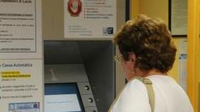Una paziente a una macchinetta per il pagamento del ticket