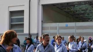 Operai all’esterno della Piaggio; per molti di loro ci sono settimane di cassa integrazione