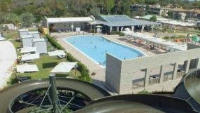 Qui sopra, l’acquapark visto dalla sommità del grande scivolo; sotto l’arrivo di alcuni clienti nel parco realizzato lungo il viale di Tirrenia