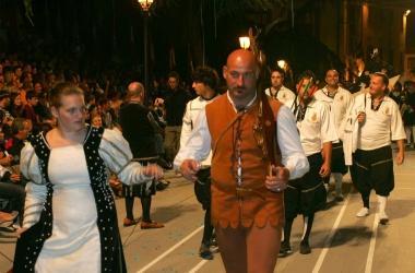 Sopra il drappo conquistato al termine del palio, a sinistra la sfilata dei campioni della squadra bianconera 