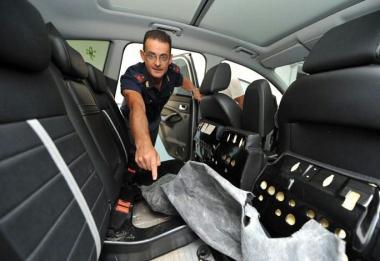 Un poliziotto mostra il vano dellauto dove era stata nascosta la droga 