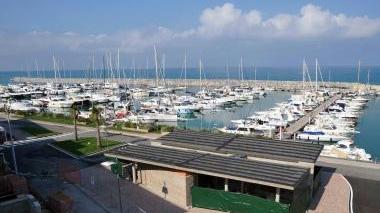 Una veduta del porto di San Vincenzo, si distingue la struttura in cemento in fase di costruzione e il cantiere a lato della Torre medicea