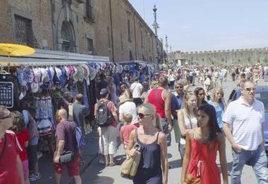 Turisti in piazza del Duomo davanti alle bancarelle di souvenir 