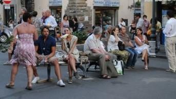 Turisti consumano panini davanti a un negozio di vicinato