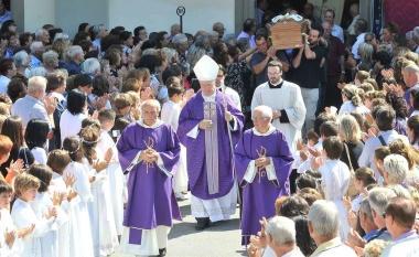 Dietro al vescovo Mansueto Bianchi il feretro esce dalla chiesa tra due ali di folla e gli applausi dei bambini della Prima Comunione  