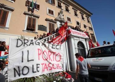 Lironia dei lavoratori del porto nello striscione portato nel corteo e poi appeso sulla parete di Palazzo Civico 