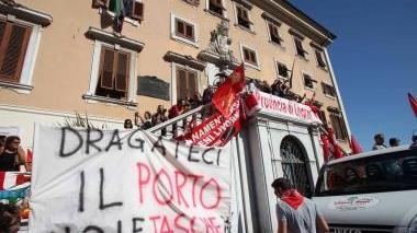 L’ironia dei lavoratori del porto nello striscione portato nel corteo e poi appeso sulla parete di Palazzo Civico