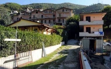 In alto: le palazzine mai terminate che creano un forte rischio frana e una veduta della strada per Arni  