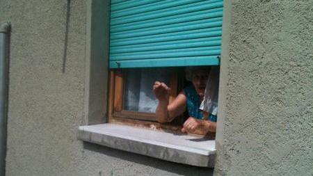 Una residente alla finestra racconta la situazione del quartiere