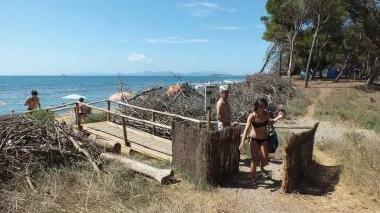 Francesca Salvini (a destra) mostra uno dei tanti acessi alla spiaggia chiusi per proteggere la duna che vengono regolarmente aperti