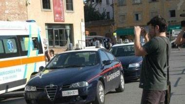 Un turista fotografa la scena del suicidio e qui sopra il corpo della ragazza coperto da un lenzuolo. Sotto, la folla di curiosi che si è attardata a vedere l’opera dei volontari e degli inquirenti ai piedi della Torre