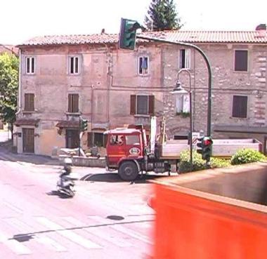 <b>ROSSO 3.</b>Un motorino passa mentre il camion parte 