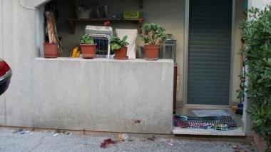 A sinistra, il cortiletto dove è caduto il bambino; sopra, una vicina di casa ancora sconvolta dopo l’accaduto; a destra, lo stenditoio che ha salvato il bambino: si vedono chiaramente i fili deformati dall’impatto che però hanno attutito la caduta