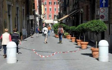Vie del centro con negozi, bar, tavolini all’esterno e insegne