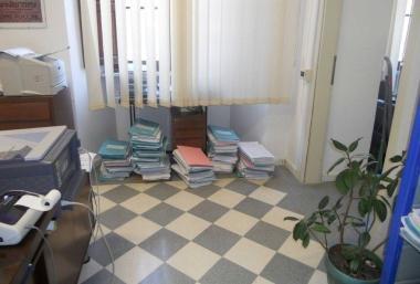 Una stanza del tribunale coi fascicoli archiviati per terra 