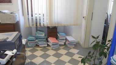 Una stanza del tribunale coi fascicoli archiviati per terra