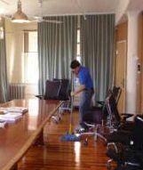 <b>PULIZIE</b> Con lo spazzolone in un ufficio   