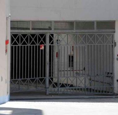 I parcheggi interrati chiusi e a destra i panni stesi in un balcone del complesso residenziale  