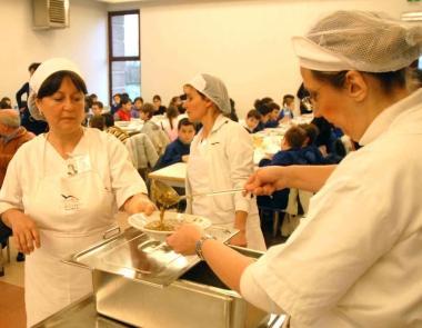 A destra si distribuiscono i pasti in una mensa scolastica Sotto una dichiarazione dei redditi 
