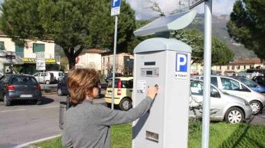 Una donna paga la sosta in un parcometro di Camaiore