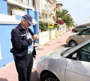 <b>SOSTA. </b>A destra un ausiliario del traffico multa unauto A lato, cittadino a un parcometro 