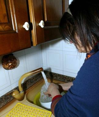 Una casalinga usa lacqua in cucina  