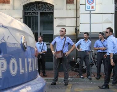 A destra alcuni lavoratori della Cap davanti alla sede di piazza Stazione, in basso il rumeno viene fatto allontanare da un poliziotto dopo che, per la terza volta, si è ripresentato con fare minaccioso agli sportelli Cap