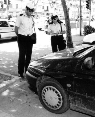Vigili urbani controllano una vettura in sosta  